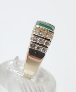 Gold ring with diamonds and green stone.