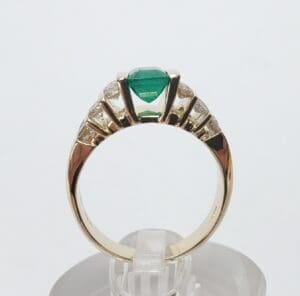 Gold ring with green gemstone and diamonds.