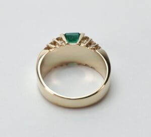 Gold ring with green gemstone and diamonds.