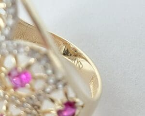 Gold ring with pink and white stones.