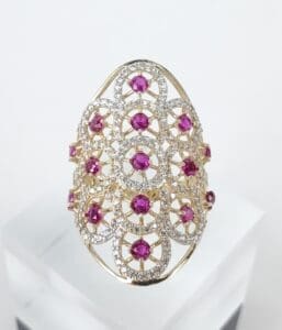 Ornate gold ring with pink gemstones.