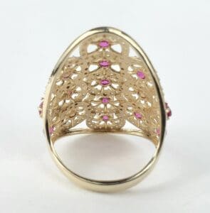 Ornate gold ring with pink gemstones.
