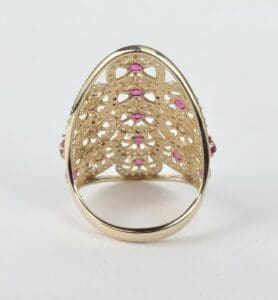 Gold ring with intricate pink gemstone design.