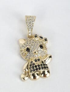 Gold cat pendant with black and white stones.
