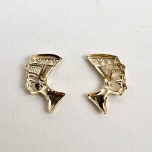 Gold Nefertiti silhouette earrings on display.