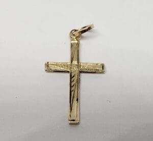 Gold cross pendant with textured design.
