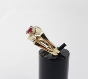 Gold ring with red gemstone on display.