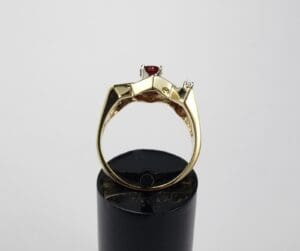Gold ring with red gemstone on display.