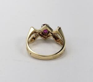 Gold ring with red gemstone setting.