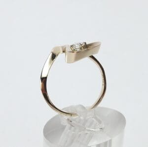 Gold ring with a diamond on display.