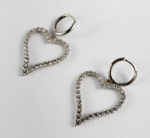 Silver heart-shaped hoop earrings with rhinestones.