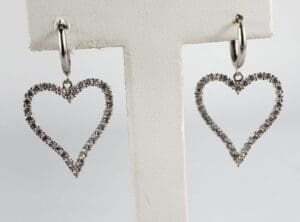 Heart-shaped diamond hoop earrings on display.