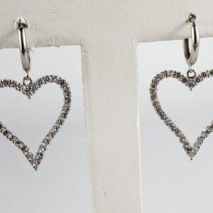 Heart-shaped diamond hoop earrings on display.