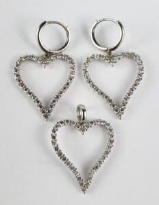 Heart-shaped silver earrings and pendant set.