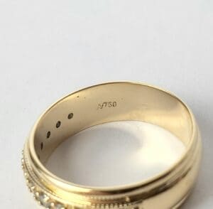 Gold ring with "750" hallmark inside band.