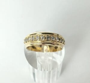 Gold ring with diamond accents displayed.