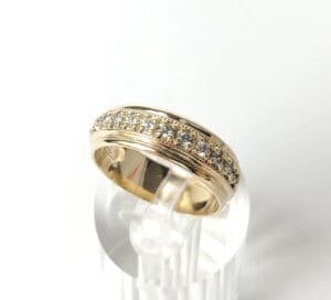 Gold ring with embedded diamonds on display.
