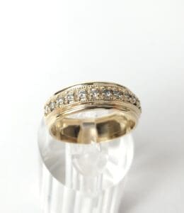Gold ring with embedded diamonds on display.