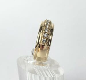 Gold ring with embedded diamonds on display.