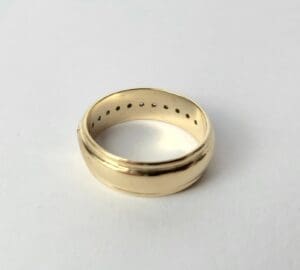 Gold ring with interior holes on surface.