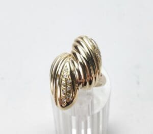 Gold ring with ribbed design and diamonds.