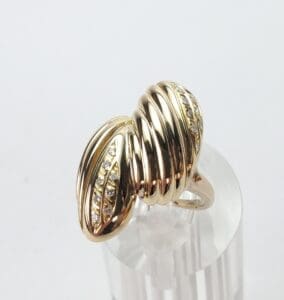 Gold ring with ribbed design and diamonds.
