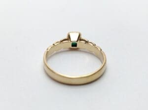 Gold ring with green gemstone setting.