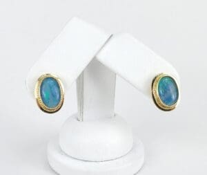 Gold earrings with oval blue opals.