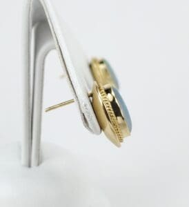 Gold earrings with blue stones displayed.
