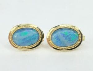 Gold earrings with oval blue opals.