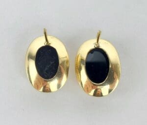 Gold oval earrings with black stones.