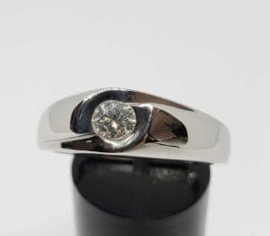Silver ring with a single round diamond.