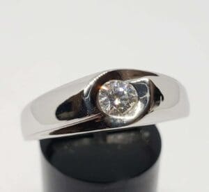 Silver ring with a single round diamond.