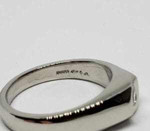 Silver ring with engraved interior marking.