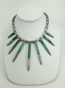 Silver and green beaded necklace on display.