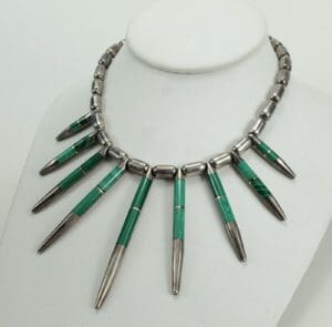 Green and silver necklace on display bust.