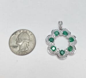 Silver flower pendant with green stones, quarter.