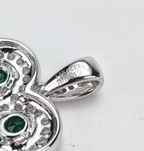 Silver pendant with green gemstones close-up.