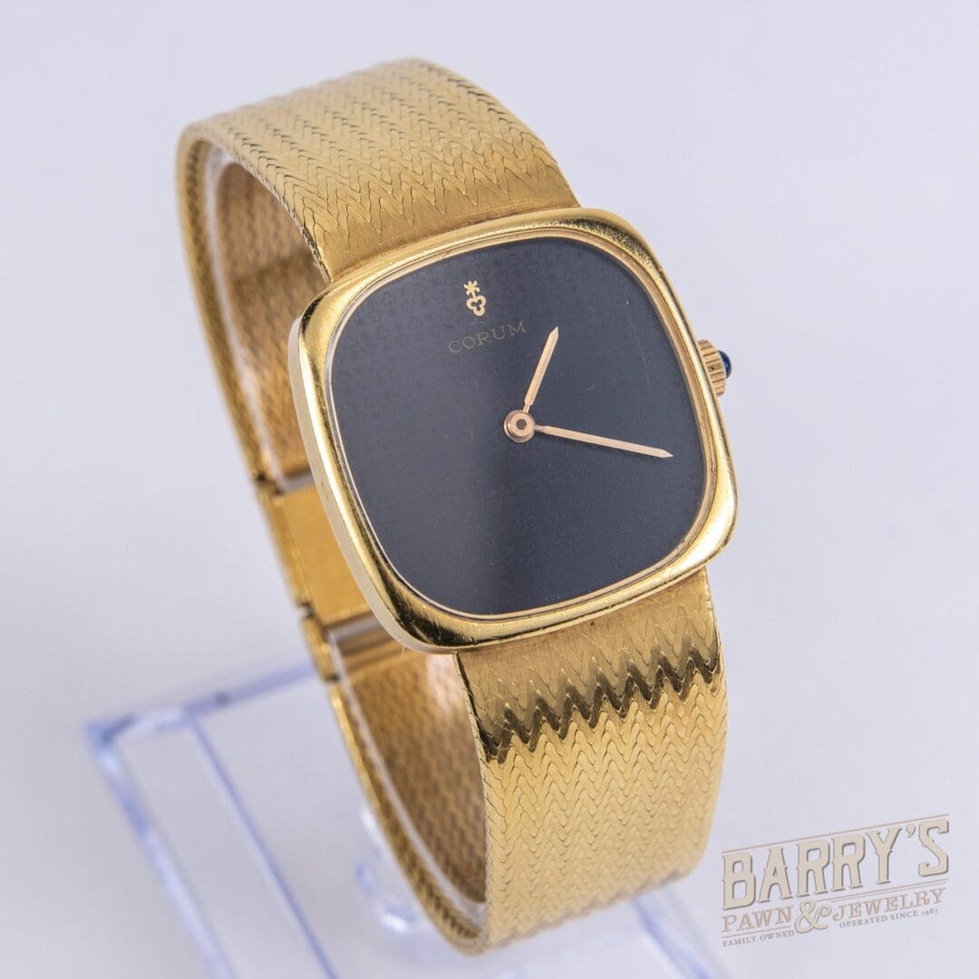 Gold watch with black square face.