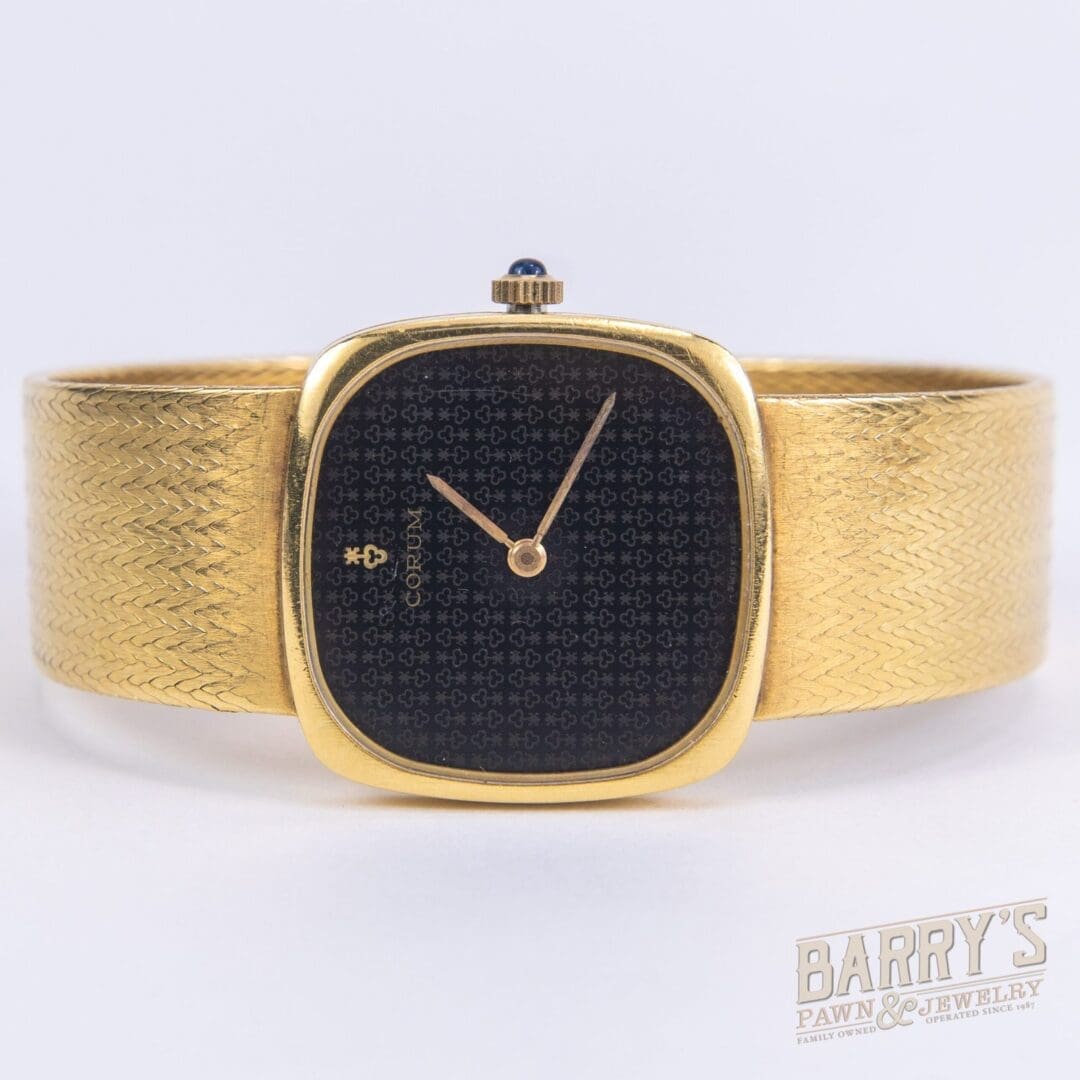 Gold wristwatch with black patterned face.