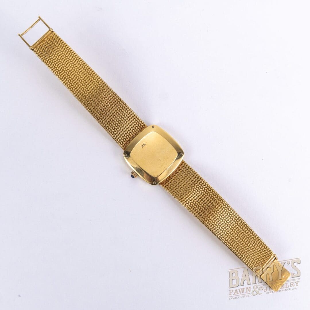 Gold watch with a mesh strap.