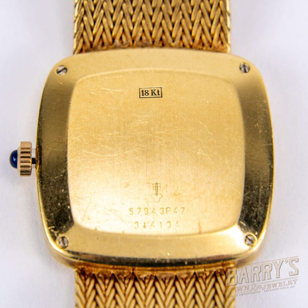 Gold watch back with woven strap.