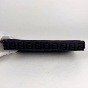 Black embossed rectangular item on white background.