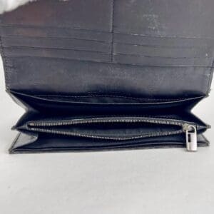 Open black leather wallet with zipper compartment.