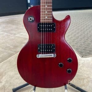 Red electric guitar on a stand.