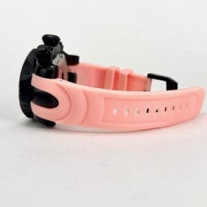 Pink wristwatch with black face, side view.