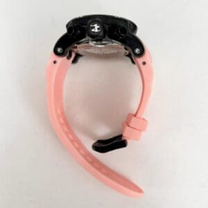 Pink watch with black face, side view.