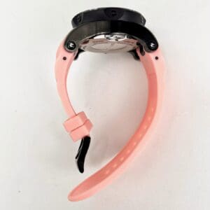 Pink watch with black round face.