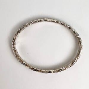 Silver braided bracelet on white background.