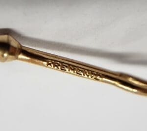 Close-up of a gold KREMENTZ marking.